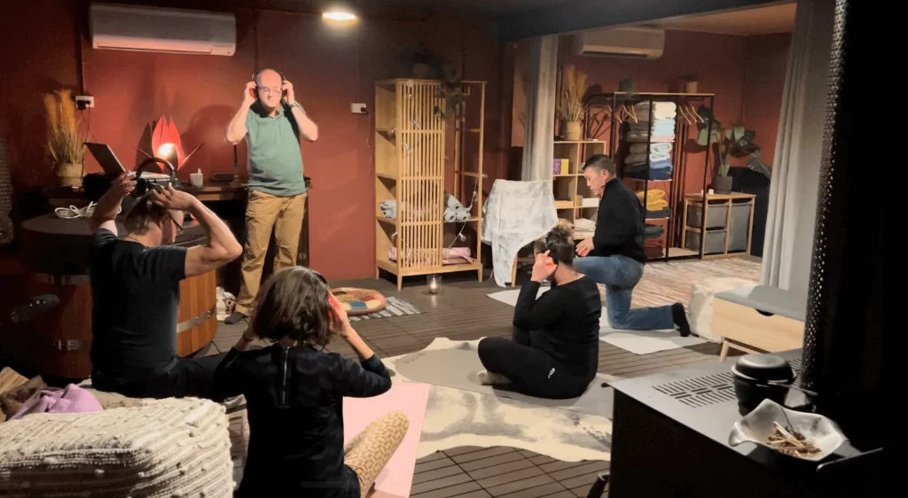 A group of individuals participating in a Soma breathwork session at Eltham Wellness Centre. The participants are lying on yoga mats with their eyes closed, deeply immersed in the practice. The serene and calming environment is highlighted by soft lighting, promoting relaxation and mindfulness.