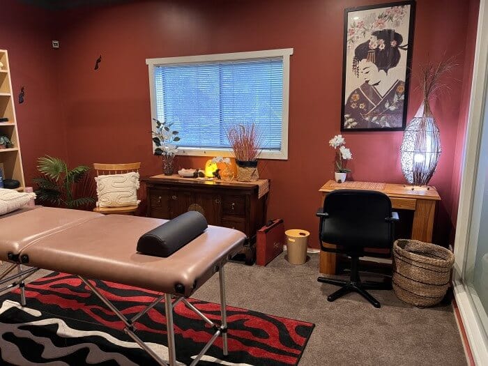 A cozy and warmly decorated massage therapy room at Eltham Wellness Centre, featuring a professional massage table, soft lighting, elegant decor, and a peaceful ambiance designed for relaxation and healing.